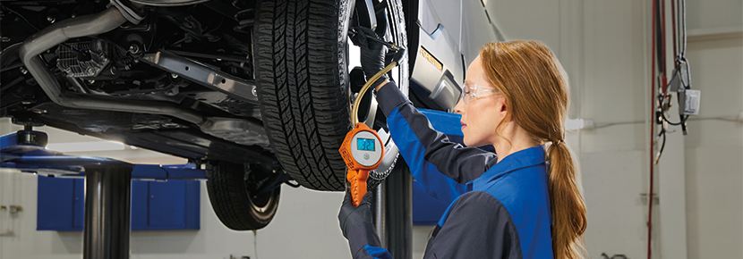 A Subaru technician checking tire pressure. | Fuccillo Subaru in Watertown NY