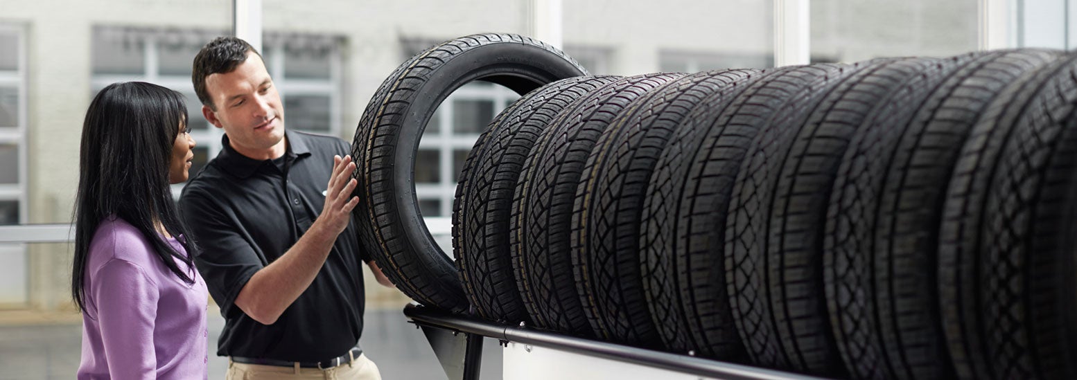 Subaru service representative showing customer a tire. | Fuccillo Subaru in Watertown NY