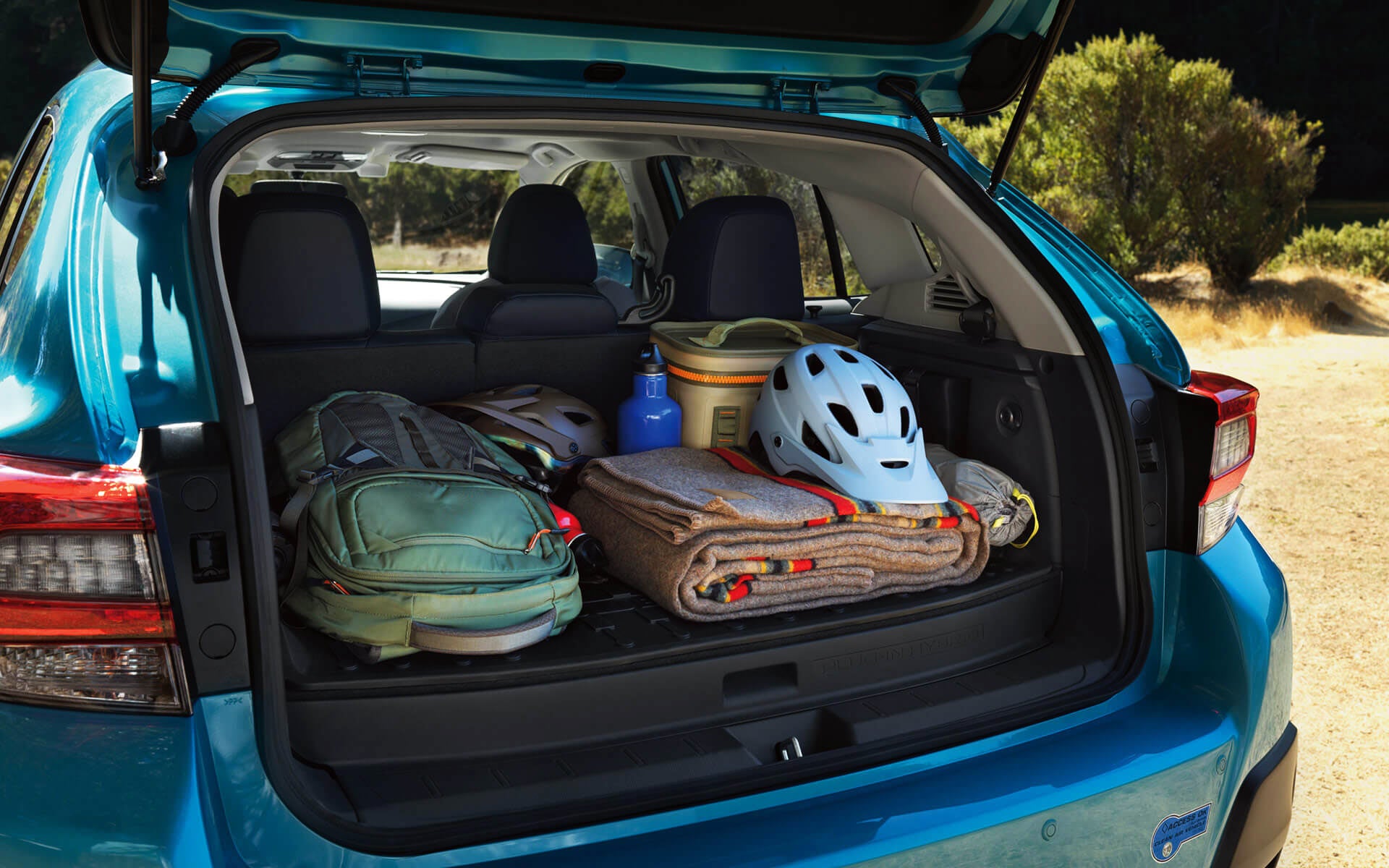 A backpack, blanket, and bike helmet in the rear cargo area of a Crosstrek Hybrid | Fuccillo Subaru in Watertown NY