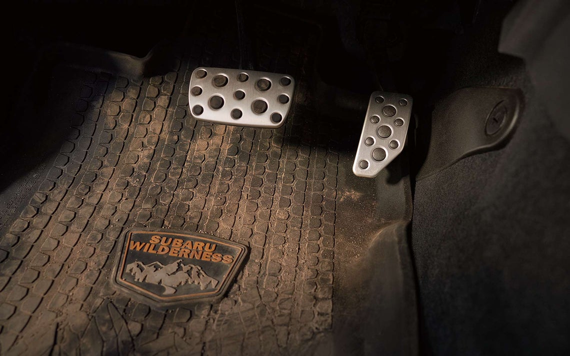 A dirty Subaru Wilderness floor mat